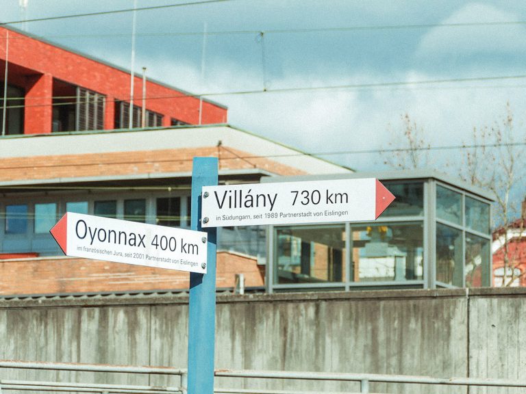 In Eislingen sind zwei Wegweiser in die Partnerstädte im französischen Oyonnax (400 km) und im ungarischen Villány (730 km) zu sehen