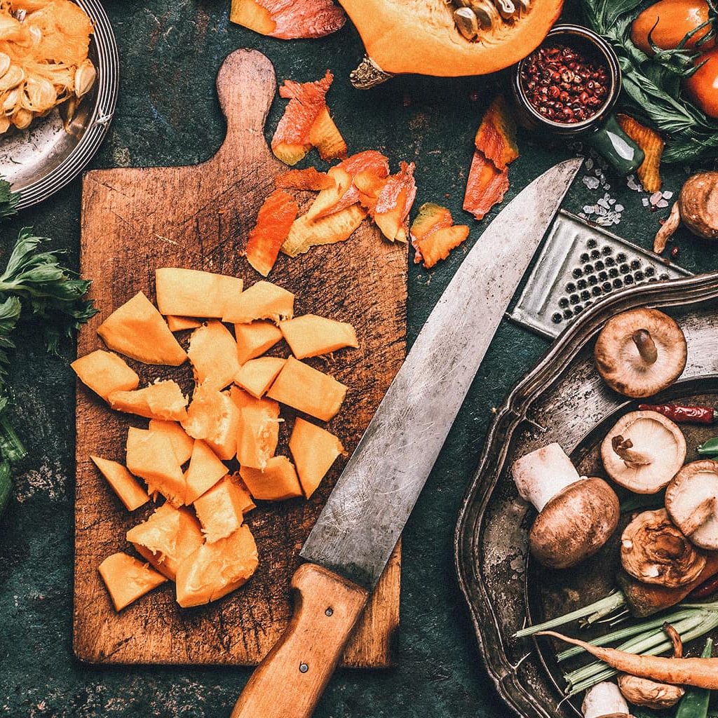Ein Tisch voller Gemüse, wie Lauch, Kürbis, Granatapfelkerne, Pilzen und Karotten