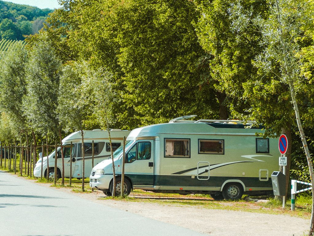 Zwei Wohnmobile parken in für sie vorgesehene Parkplätze auf einem Campingplatz