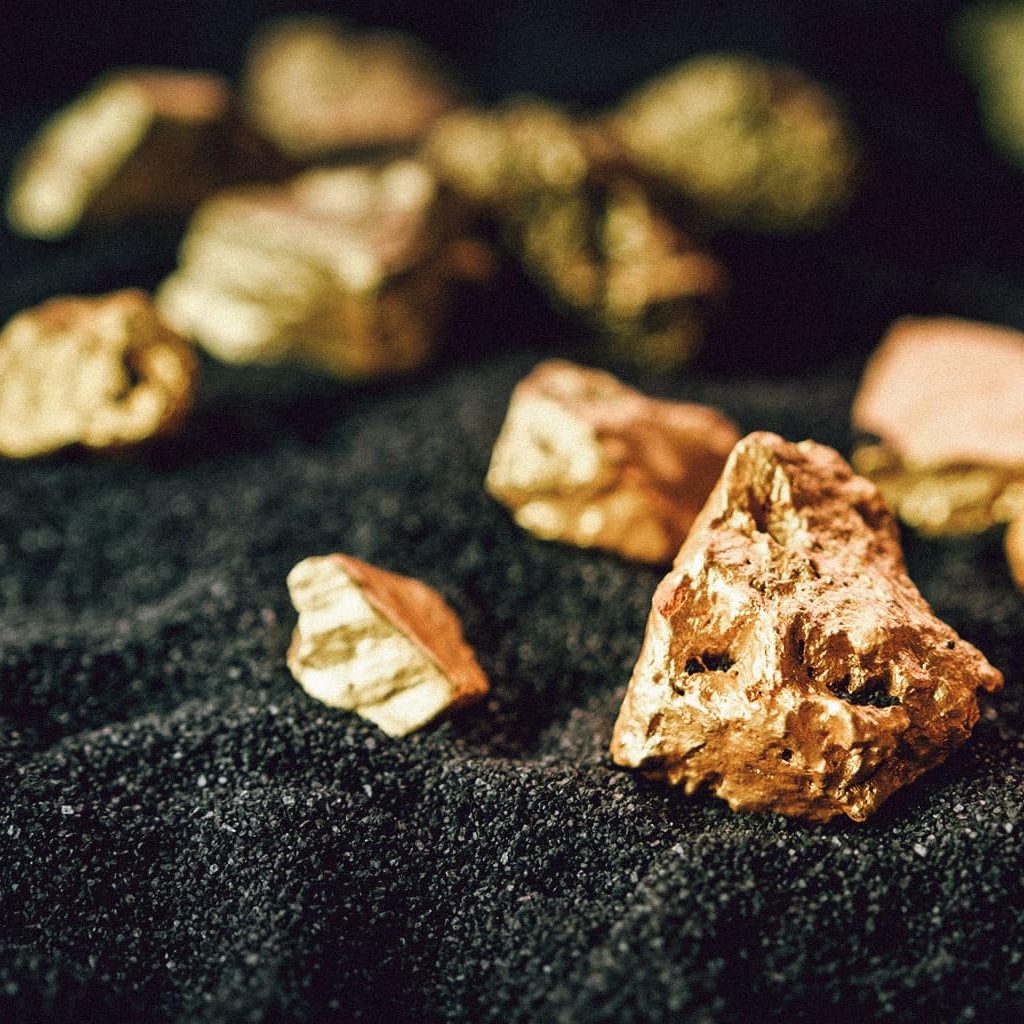 Gold-Nuggets in verschiedener Größe auf einem schwarzen Tuch