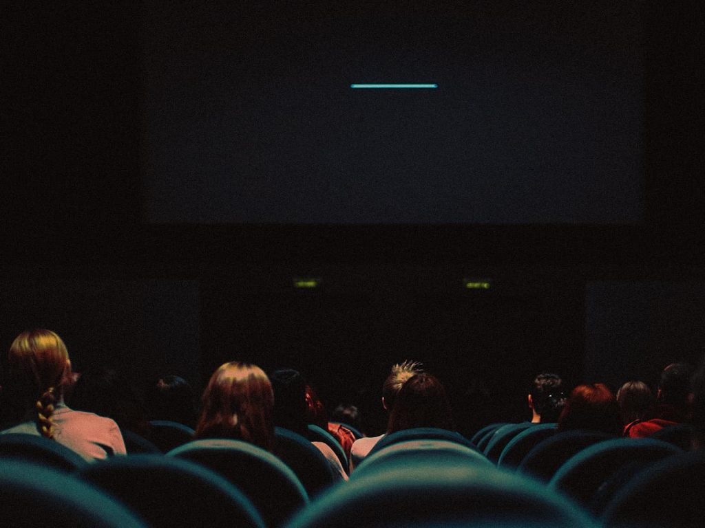 Besucher in einem Kinosaal sitzen und warten auf den Filmstart