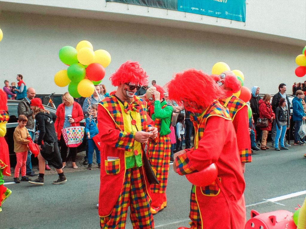 Eine Gruppe von Clowns unterhält sich während eines Umzugs bei einem Kinderfest