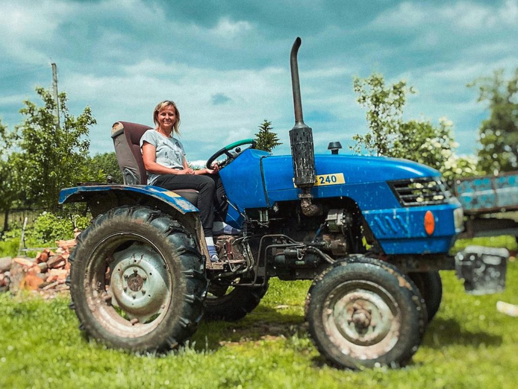 Eine Frau sitzt auf einem blauen Traktor