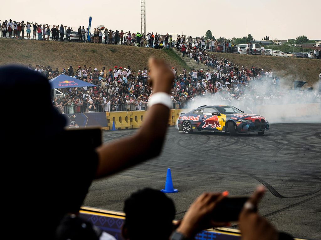 Ein Auto der Red Bull Driftbrothers driftet vor begeisterten Zuschauern auf der Rennbahn