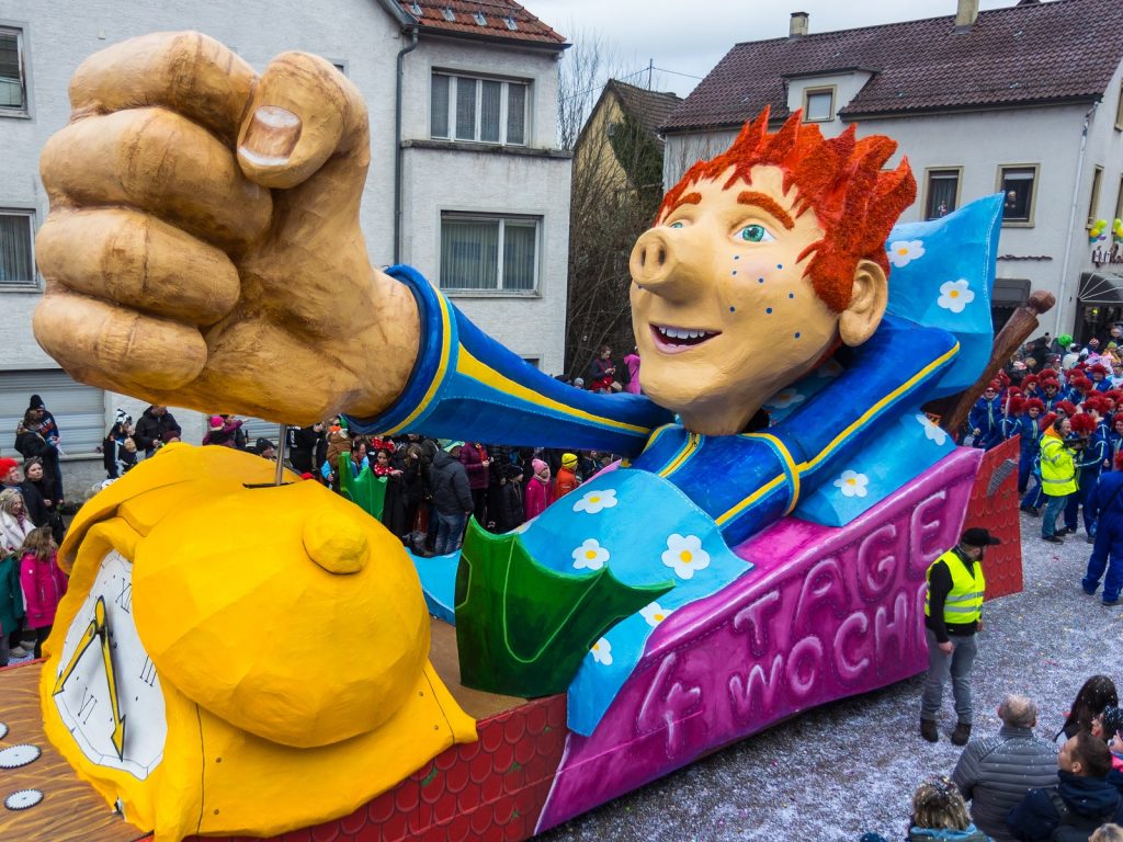 Der Wagen des Stammtisch Schraubaglaubr zeigt das Sams, eine Kinderbuchfigur mit einer Rüsselnase, blauen Punkten im Gesicht und roten Borstenhaaren, die auf einen Wecker haut. Auf dem Wagen steht '4 Tage Woche'.