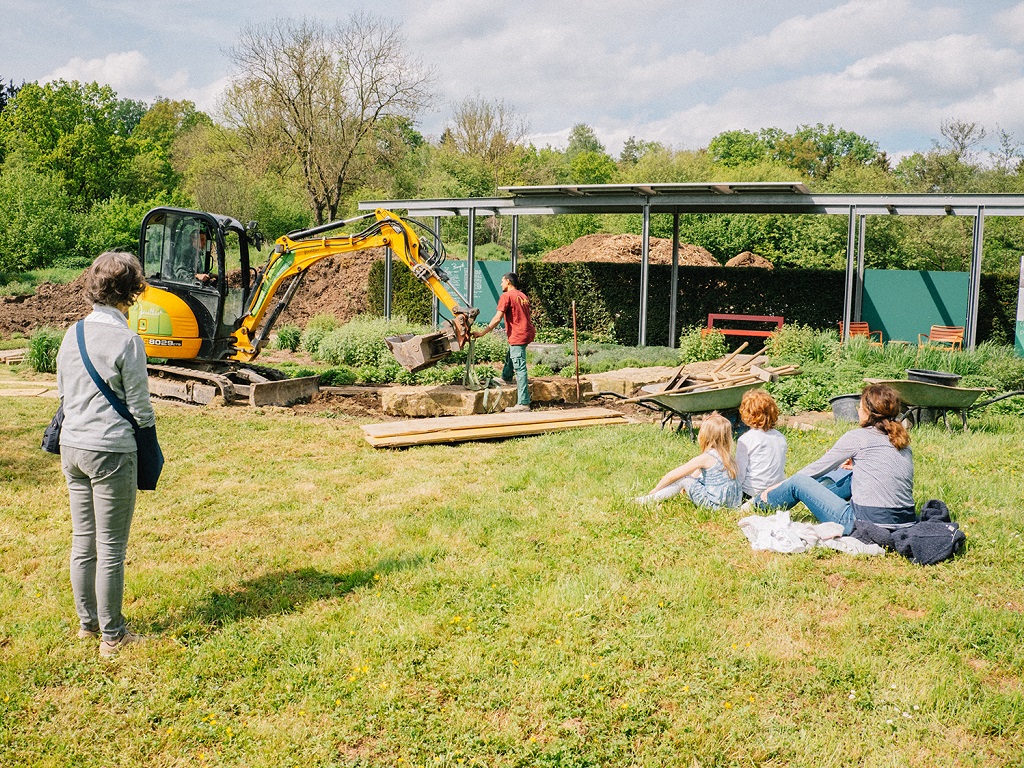 Besucher beobachten beim Frühlingsfest im Gärtnerhof Jeutter Gärtner bei der Arbeit – ein Einblick in die Praxis professioneller Gartenpflege.