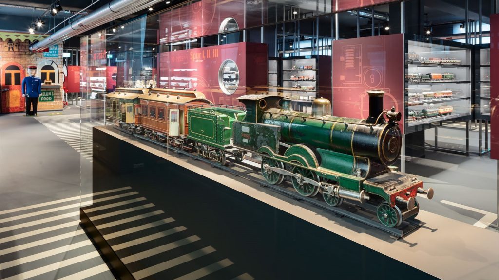 Ausstellung im Märklineum Göppingen mit historischer Modelleisenbahn in Glasvitrine vor modernem Ausstellungsdesign.