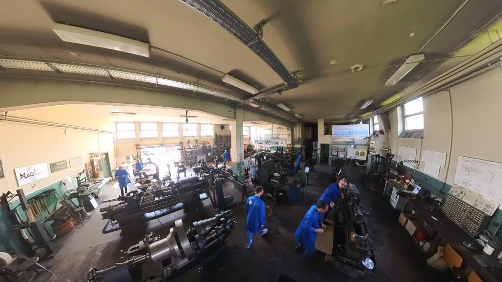 Blick in die historische Maschinenhalle des Göppinger Technikforums mit mehreren Dreh- und Fräsmaschinen, Vereinsmitgliedern in blauen Kitteln und Boehringer-Schriftzug im Hintergrund.