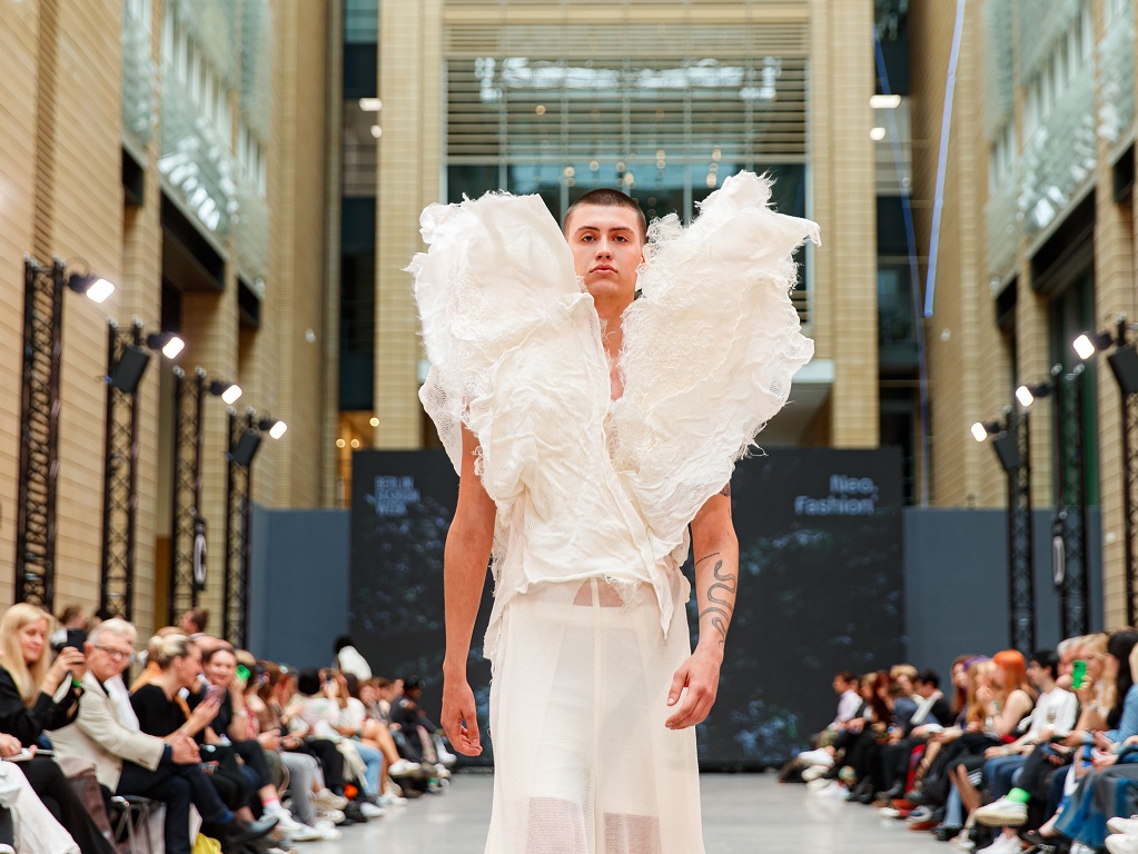 Model mit avantgardistischer Abendrobe aus Laubholzfasern auf dem Laufsteg der Berlin Fashion Week 2024 – Kollektion WDBSD TX® des Technikums Laubholz