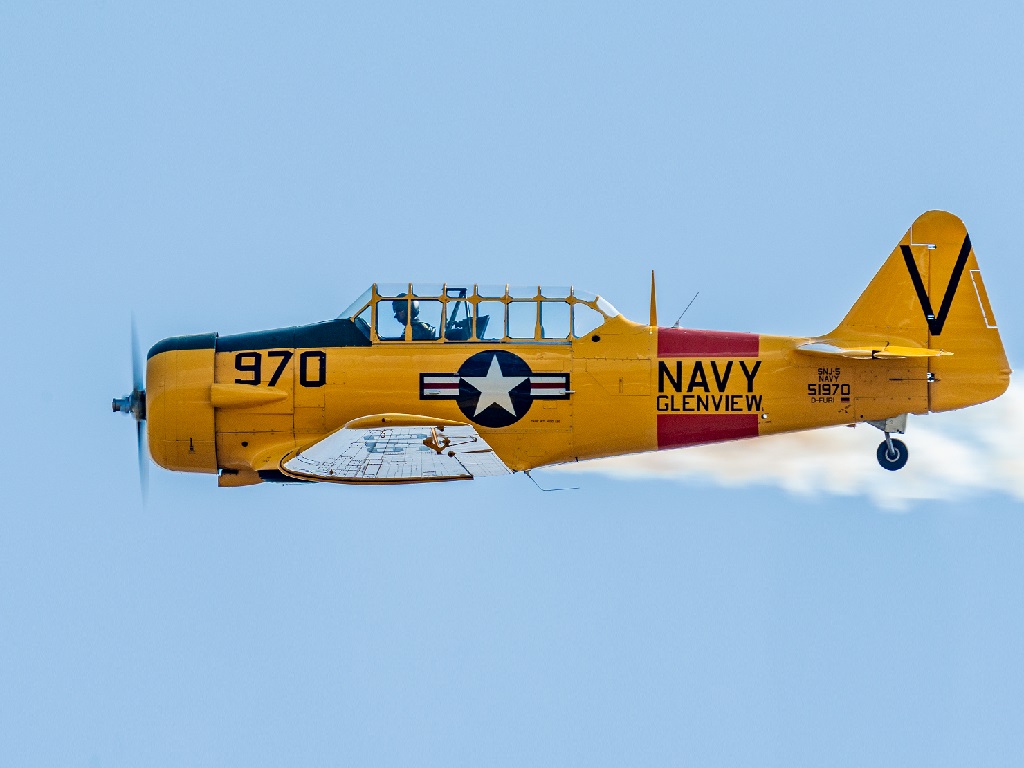 Das Flugtage Donzdorf 2025 Highlight: Eine Gelb lackierte North American T-6 im Flug vor blauem Himmel, mit sichtbarem Stern-Emblem der US Navy und der Kennung „970“, geflogen von Peter Gutmann.