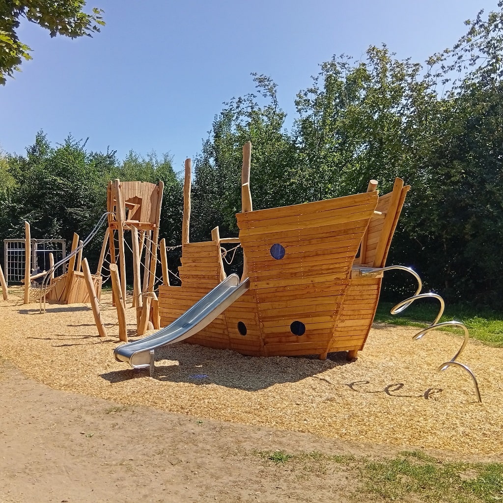 Großes Holz-Piratenschiff mit Rutsche auf einem Spielplatz