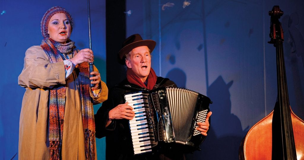 Zwei Künstler mit Akkordeon und Geige in stimmungsvoller Beleuchtung – Szene aus dem musikalisch-literarischen Adventsprogramm „In stiller Nacht“.