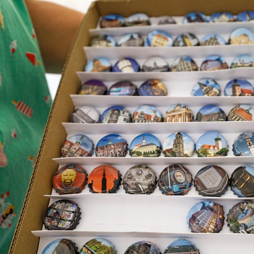 Kronkorken mit Architekturmotiven, sortiert im Setzkasten