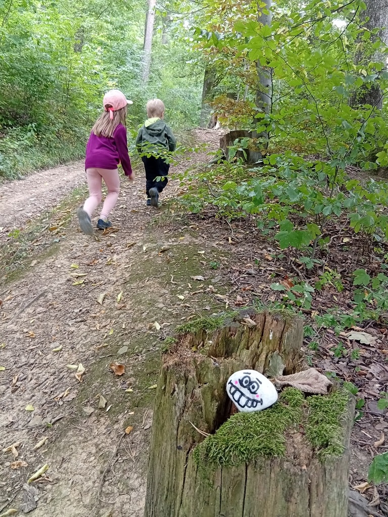 Kinder entdecken bemalte Steine auf dem Steingesichter-Pfad in Bad Boll