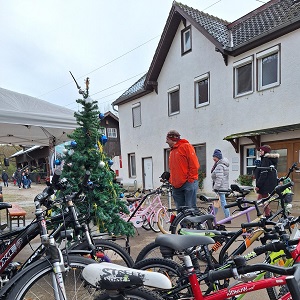 Fahrradwerkstatt auf dem Weihnachtsmarkt am Waldeckhof mit einer Auswahl an Kinderrädern und winterlicher Dekoration.