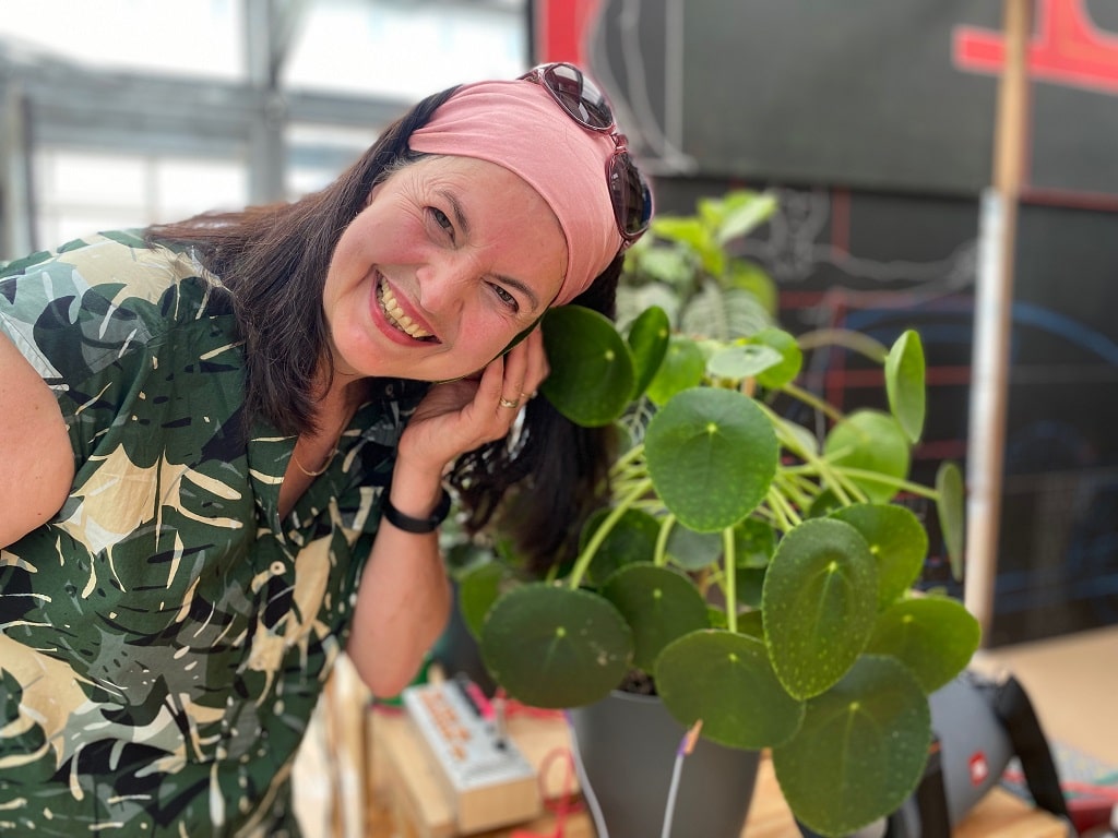 Cassis B Staudt erzeugt Pflanzenmusik in der Ausstellung Furry Flowers und arbeitet dabei mit einer Pflanze, die mit Elektroden verbunden ist.