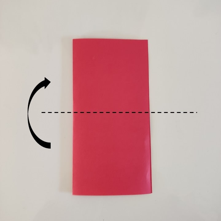 Das längs gefaltete Papier wird quer mittig gefaltet, die Faltlinie ist gestrichelt markiert.