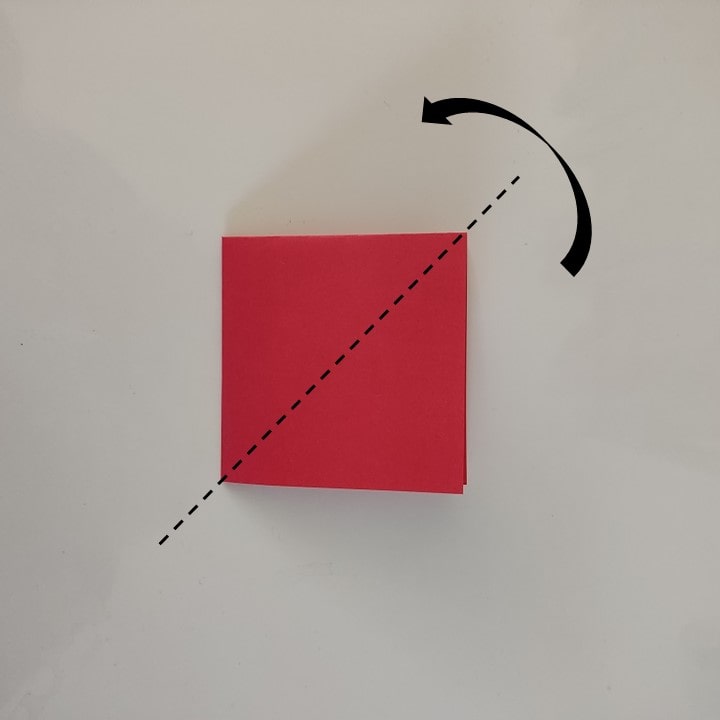 Das längs gefaltete Papier wird quer mittig gefaltet, die Faltlinie ist gestrichelt markiert.