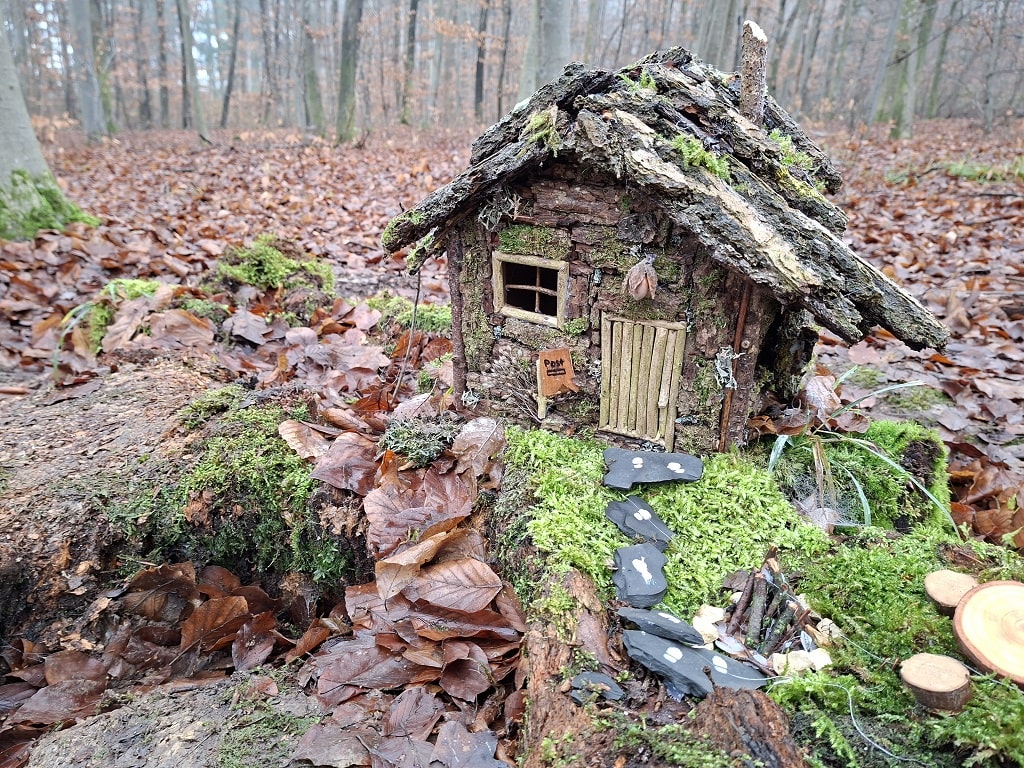 Wichtelhäuschen aus Naturmaterialien im winterlichen Wald auf dem Ohmdener Wichtelweg
