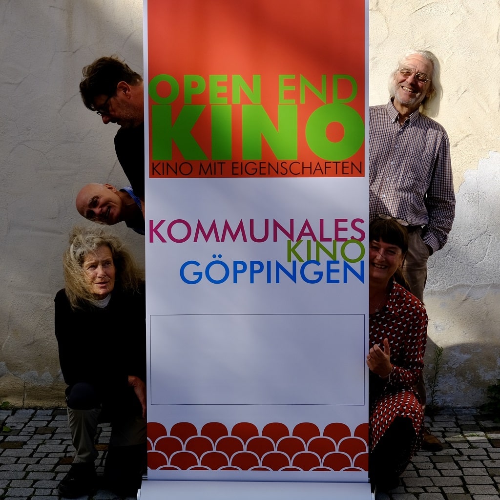 Team des OPEN END KINO vor dem Banner des kommunalen Kinos Göppingen, das zum Jahresausklang den Film „Manche mögen’s falsch“ von Stanislaw Mucha präsentiert.