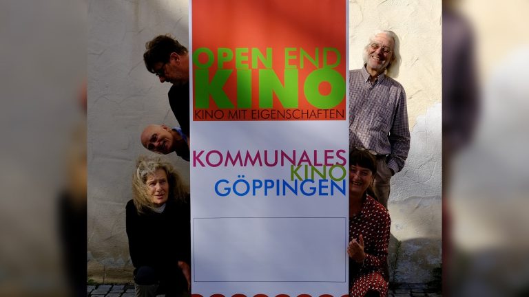 Mitglieder des Vereins OPEN END KINO Göppingen posieren fröhlich um ein großes Banner mit der Aufschrift „Open End Kino – Kommunales Kino Göppingen“.