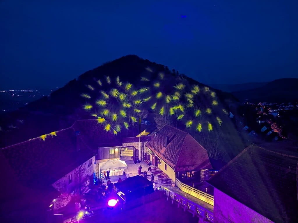 Lichtinszenierung und Besucher im Innenhof der Burg Hohenrechberg beim Winterzauber