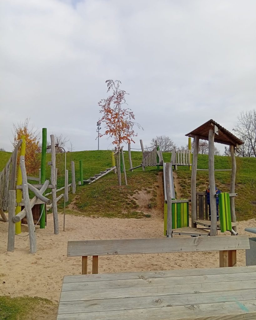 Holzspielplatz für Kinder am Biodiversitätspfad Hardt mitten im Grünen.