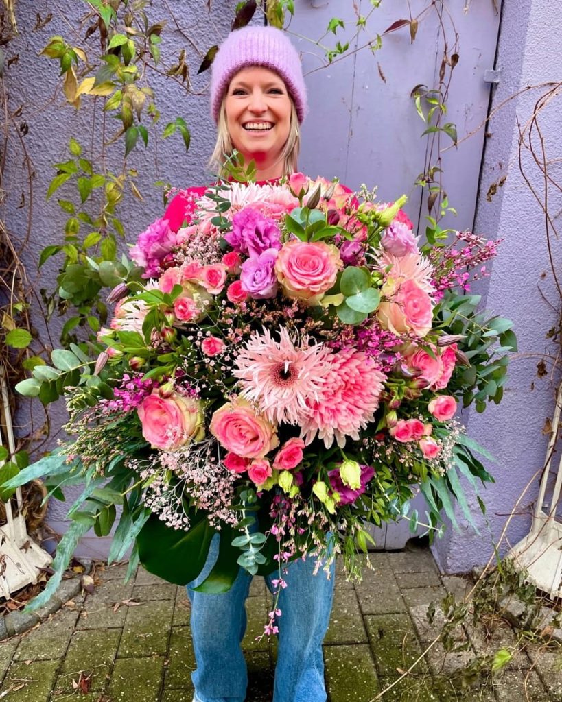 Floristin der binderei Göppingen mit einem individuell gebundenen Blumenstrauß