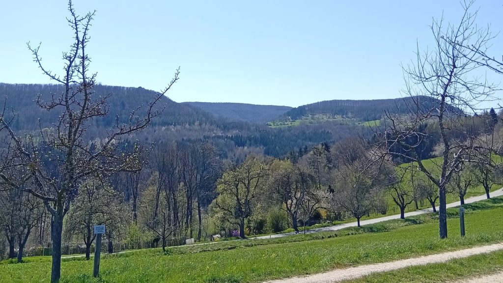 Frühlingshafte Landschaft mit Obstbäumen, Wiesen und Blick auf die Hügel rund um den Osteraktivpfad in Gingen an der Fils.