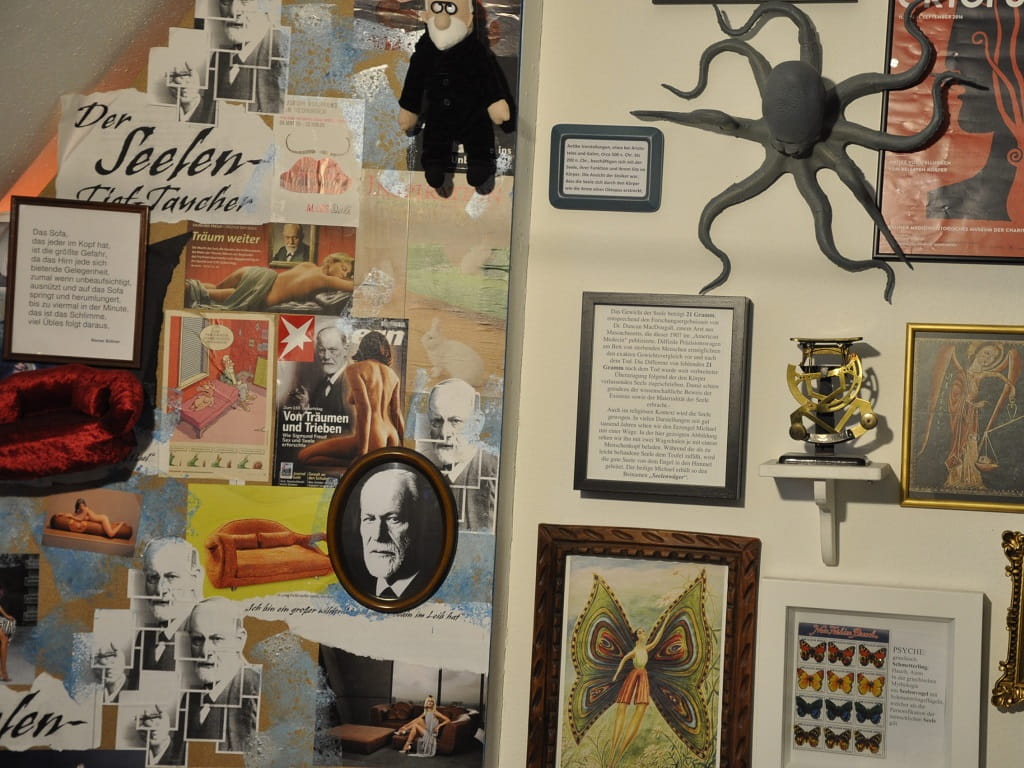Ausstellungsansicht im MuSeele mit Collage zu Sigmund Freud, historischen Abbildungen und medizinischen Objekten an der Wand.