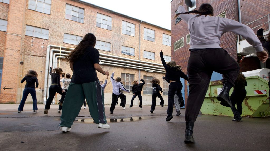 TANZ-LAND-FLUSS im Filstal: Gruppe von Tänzerinnen und Tänzern bewegt sich gemeinsam auf einem Industriegelände zwischen Backsteingebäuden