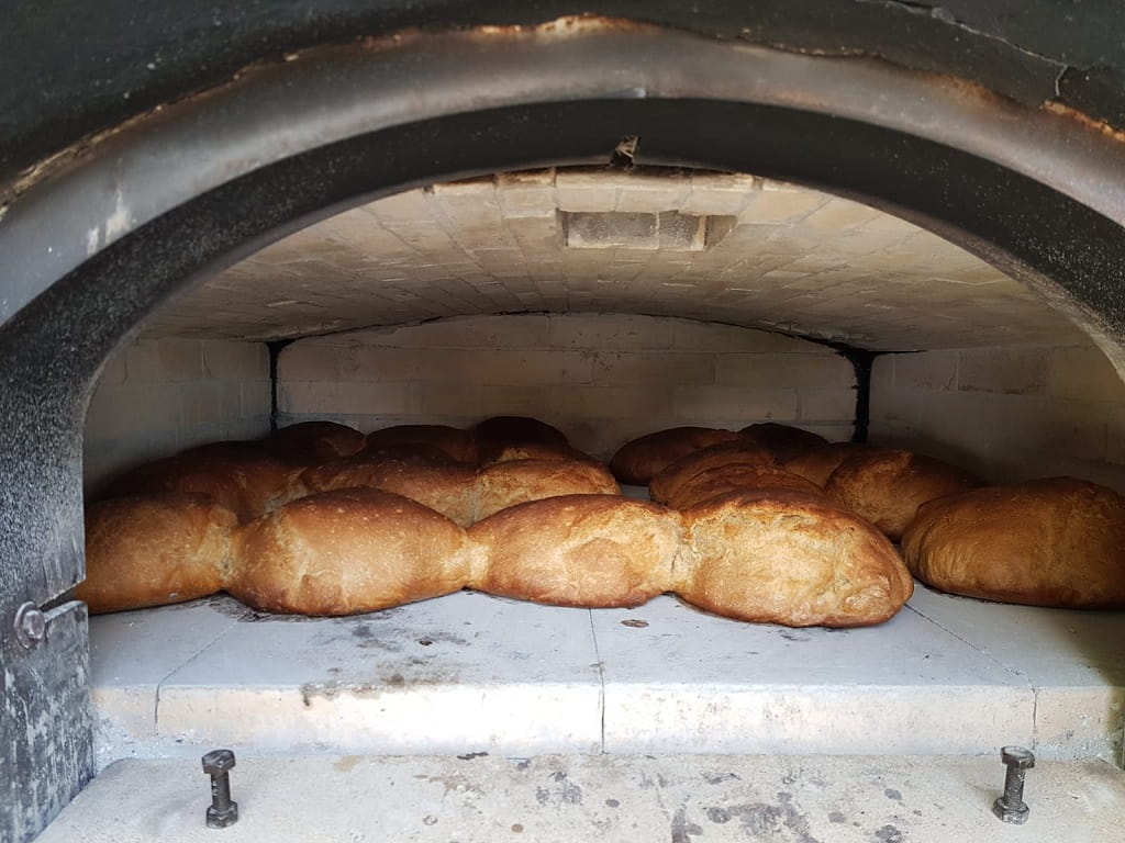 Frisch gebackene Brote liegen beim Brotbacken auf dem Hohenstaufen im Holzbackofen.