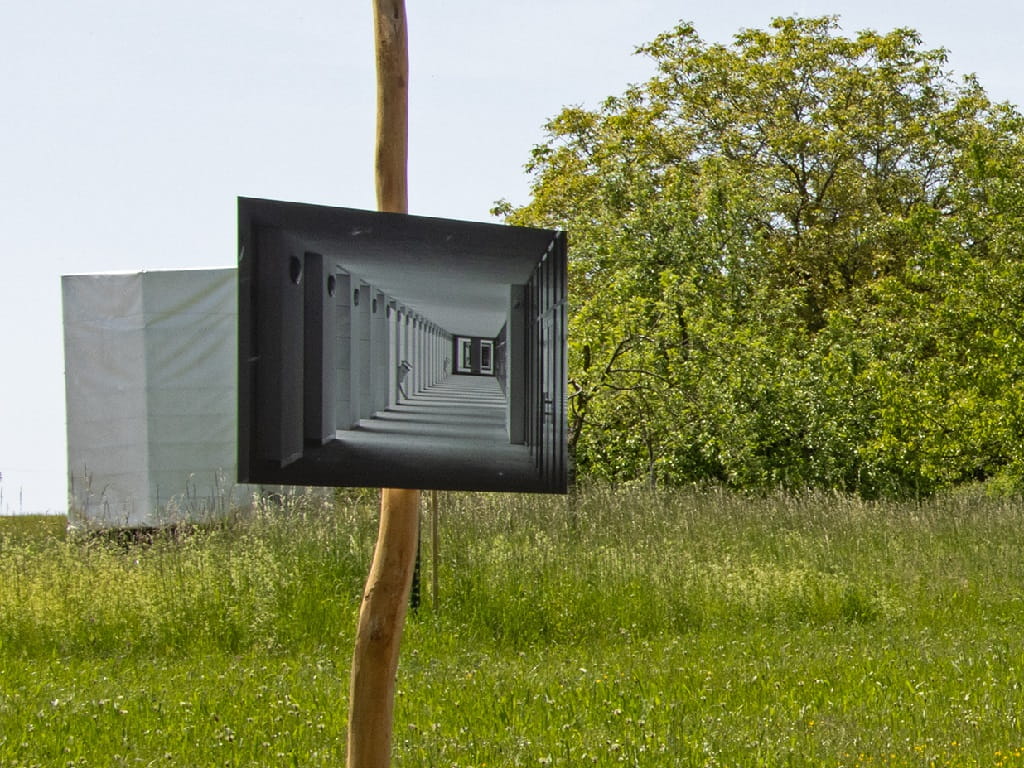 Eine schwarz-weiße Architekturfotografie hängt auf einer Holzstele auf einer Wiese in Albershausen und ist Teil der Jubiläumsausstellung des Fotoclubs Albershausen.