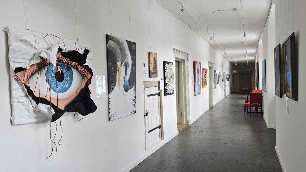 Ausstellungsansicht im Nordflügel mit Werken von Michael Ferk, darunter ein großes Augenmotiv im Vordergrund.