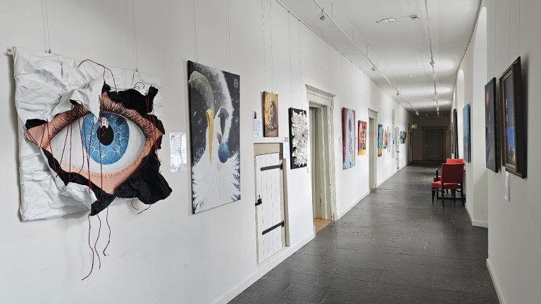 Ausstellungsansicht im Nordflügel mit Werken von Michael Ferk, darunter ein großes Augenmotiv im Vordergrund.