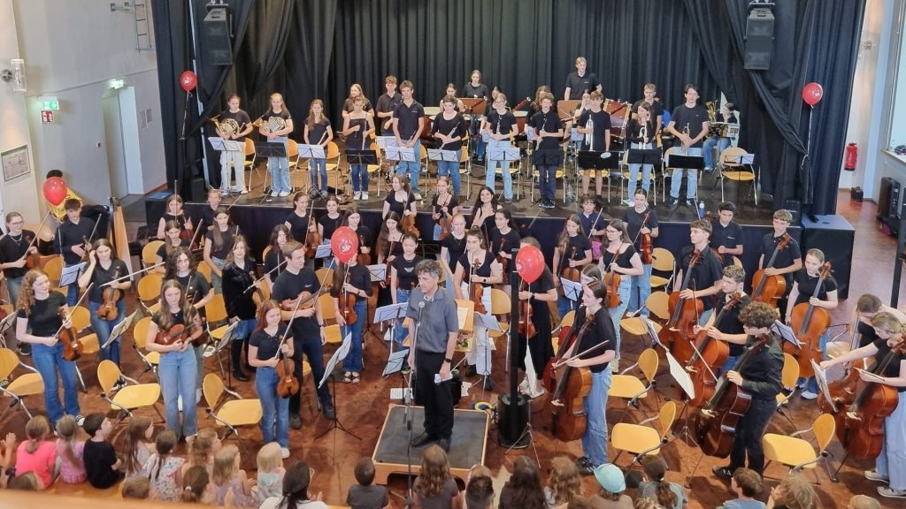 Das Göppinger Jugendsinfonieorchester steht beim Kinderkonzert im Alten E-Werk auf der Bühne, während Kinder im Publikum zuhören.