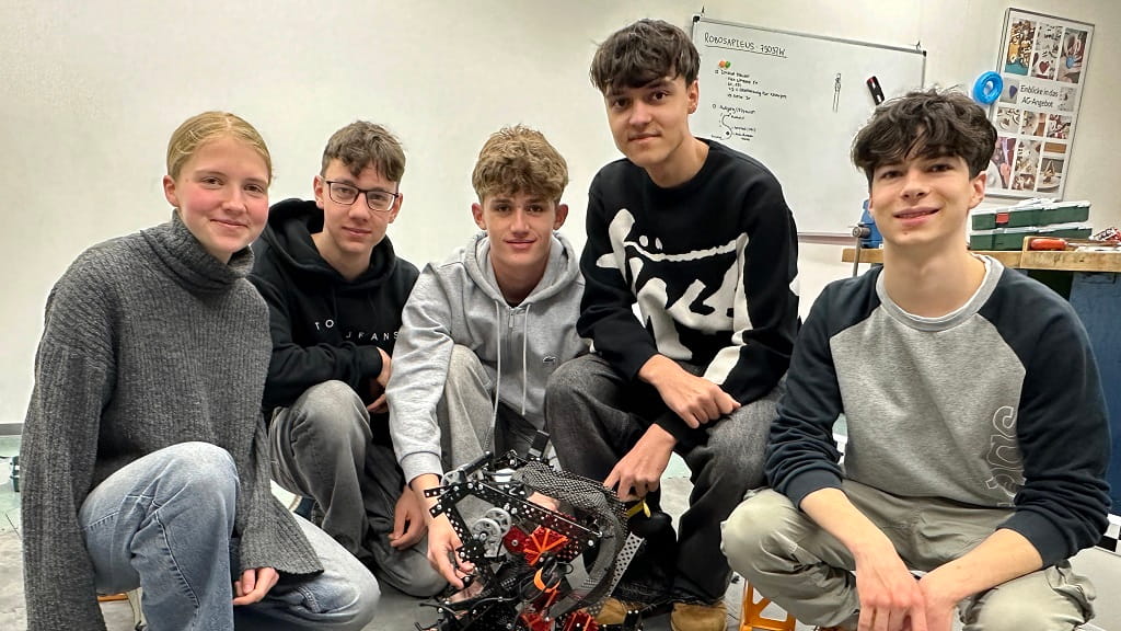 Jugendliche des VEX-V5-Teams „Robosapiens“ mit ihrem Roboter vor dem Vortrag „Von der Werkbank zur Weltmeisterschaft“