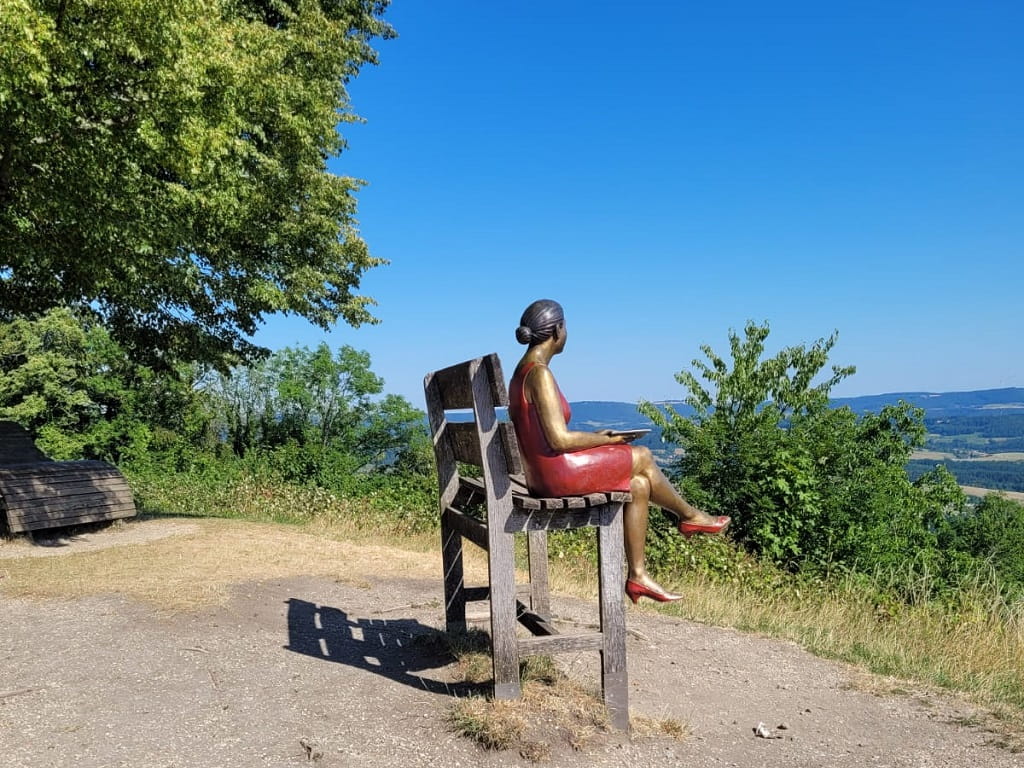 Frau im roten Kleid an einem Aussichtspunkt auf dem Hohenstaufen