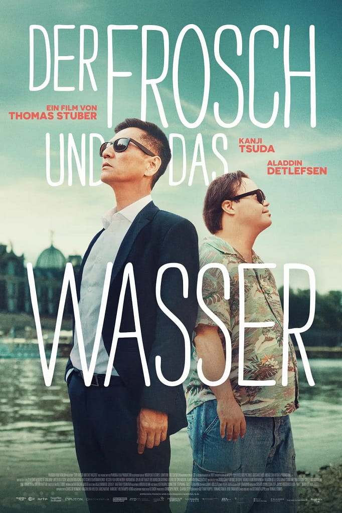 Filmplakat zu „Der Frosch und das Wasser“ mit zwei Männern, die Rücken an Rücken vor einer Wasserlandschaft stehen