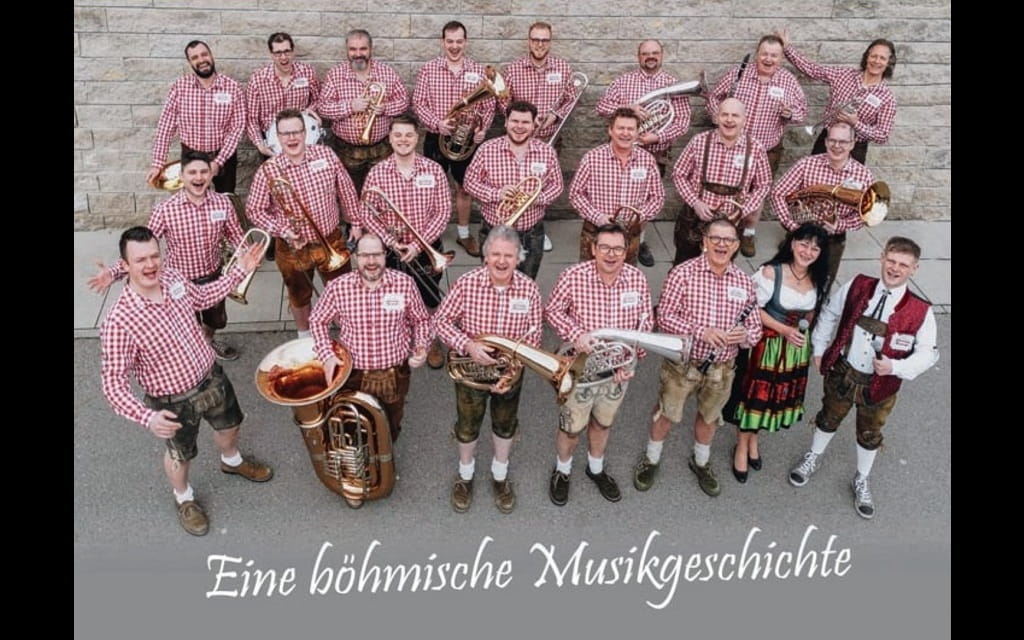 Föhrenberger Blasmusik mit Musikerinnen und Musikern in rot karierten Hemden und Instrumenten.