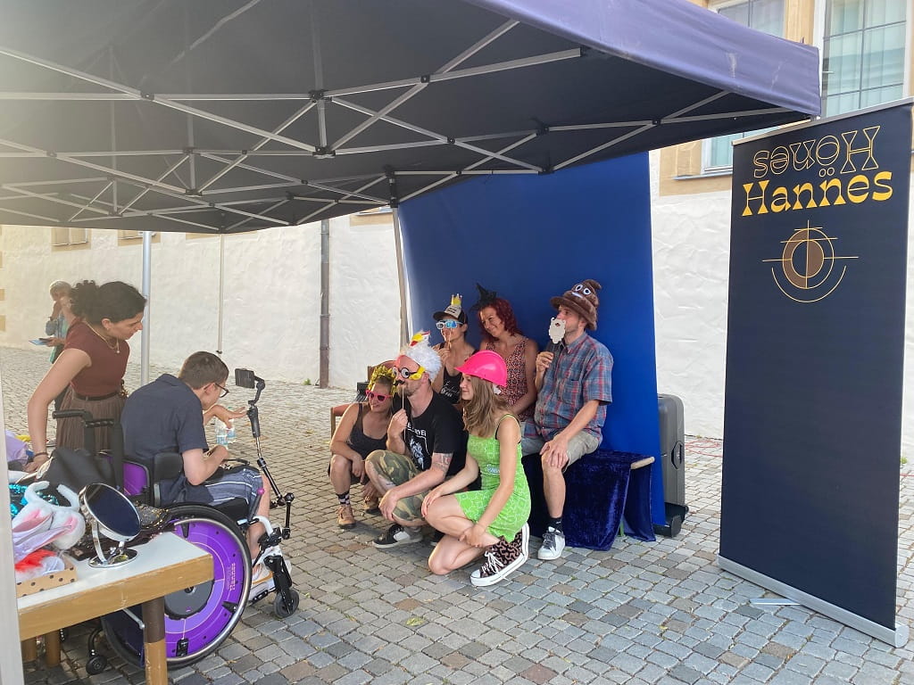 Hannes Hönes fotografiert eine kostümierte Gruppe vor der lebendigen Fotobox.