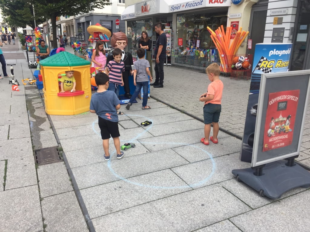 Kinder spielen mit ferngesteuerten Autos vor Korb Rau bei „Göppingen spielt!“ in der Göppinger Innenstadt.