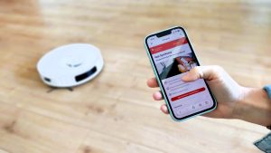 Eine Person hält ein Smartphone in der Hand. Auf dem Display erscheint ein eingehender Anruf mit der Anzeige „Unbekannt“.