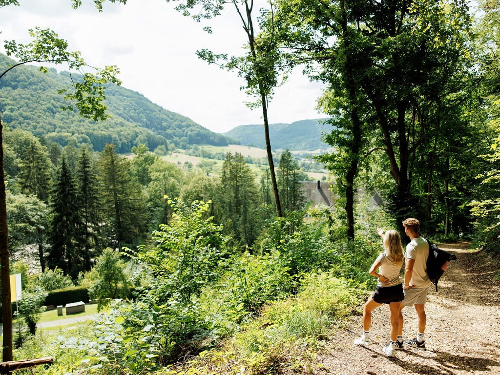Paar auf einer Holzliege mit weitem Blick über die Landschaft.