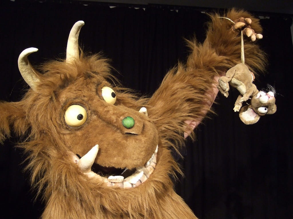 Grüffelo hält eine kleine Maus in der Hand auf der Bühne des marotte-Theaters