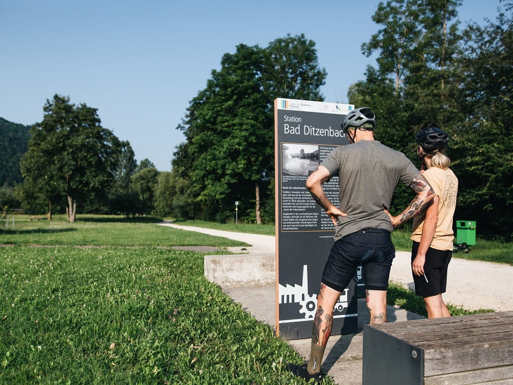 Zwei Radfahrende an der Station Bad Ditzenbach der Route der Industriekultur im Filstal