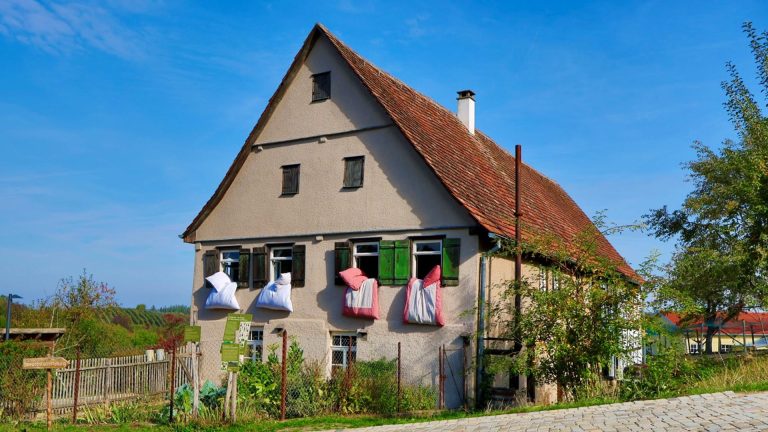 Historisches Bauernhaus mit bunten Bettdecken im Freilichtmuseum Beuren