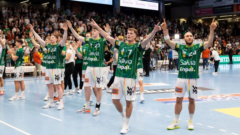 Spieler von FRISCH AUF! Göppingen stehen mit erhobenen Armen vor den applaudierenden Zuschauern in der EWS Arena.